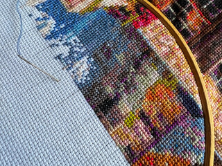 Fragment of cross-stitch on white fabric.