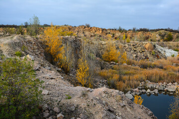 Flooded granite quarry White rocks near village Aktove, Ukraine. Colorful leaves of trees in the autumn landscape, colors of leaf-fall.