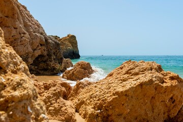 Orange rock formations on the sandy beach in Portugal