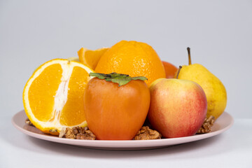 Fruits of orange and yellow colors - apples, persimmons, pears and oranges.