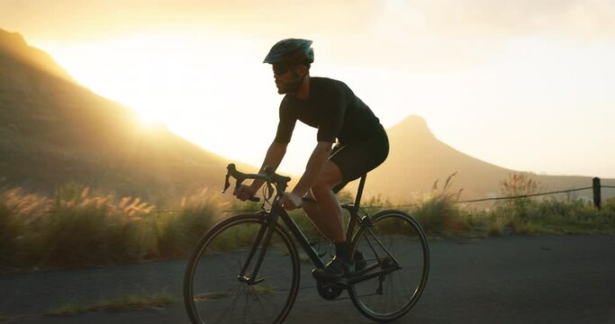 Fitness, man and cycling on road in mountain sports, exercise or workout during sunset in nature. Active male riding bicycle in the mountains for healthy cardio, training or outdoor cycle tour