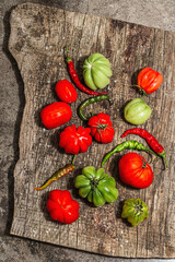 Green and red ribbed tomatoes on a vintage wooden stand. American or Florentine variety