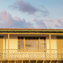 Square Puffy clouds at sunset Low angle view of a balcony with two double doors and shutters a