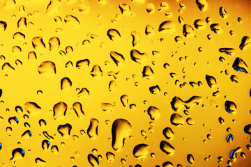 Water drops background. Wet glass surface texture. Bad autumn weather rainy day. Bubble dew pattern. Transparent window orange raindrops. Bright environment condensation texture.
