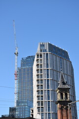 Modern buildings under construction with large cranes and machinery. 