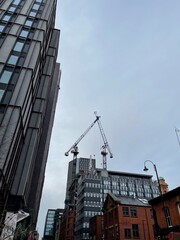 Fototapeta premium Modern buildings under construction with large cranes and machinery. 