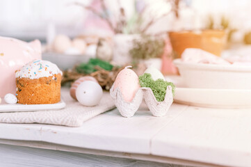 happy easter and spring holidays time. festive tablescape set decor. traditional dinner food easter eggs and baked cakes on table at home. rabbit and willow. pale pop pastel blue and pink color. flare