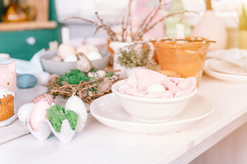 happy easter and spring holidays time. festive tablescape set decor. traditional dinner food easter eggs and baked cakes on table at home. rabbit and willow. pale pop pastel blue and pink color. flare