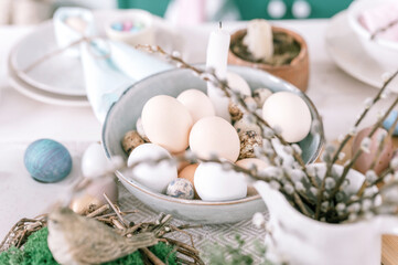 happy easter and spring holidays time. festive tablescape set decor. traditional dinner food easter eggs in plate on table at home. pale pop pastel green and pink color