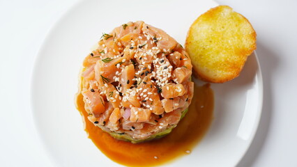 Raw Salmon tartar with avocado, and lemon hashed avocado, with spices, and sesame