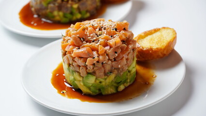 Raw Salmon tartar with avocado, and lemon hashed avocado, with spices, and sesame