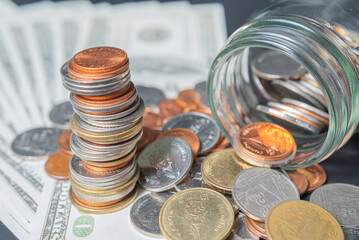 Thailand coins in jar with heap coins on on dollar banknote