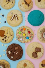 Fotobehang Cookies in different colors decorated with chocolate bars, and crumbs © Nina Ljusic/Wirestock Creators
