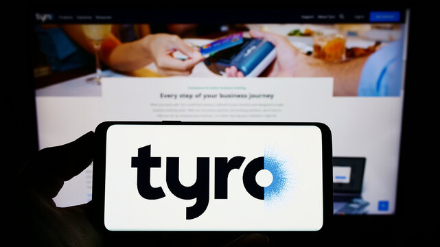 Stuttgart, Germany - 10-24-2022: Person holding smartphone with logo of Australian fintech company Tyro Payments Limited on screen in front of website. Focus on phone display.