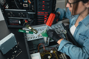 Woman soldering desktop computer with desoldering gun