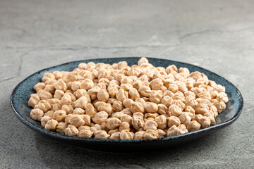 Raw chickpeas in the plate on the table.