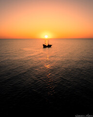 Samotna ł&oacute;dz o zachodzie słońca