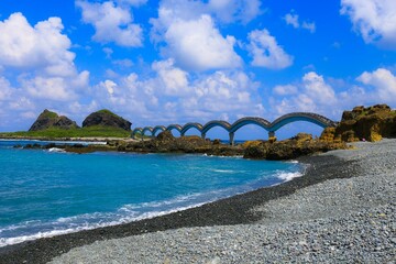 Lovely view of the Sanxiantai nature preserve in Taiwan with a bright blue sea under a cloudy sky