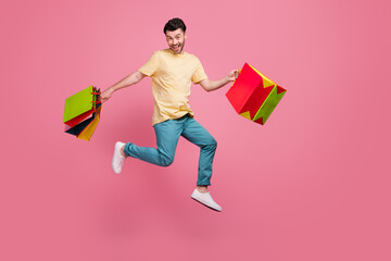 Full length photo of positive overjoyed man wear trendy clothes moving empty space carry packs...