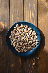 Pistachios on a plate on a wooden table
