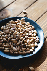 Pistachios on a plate on a wooden table