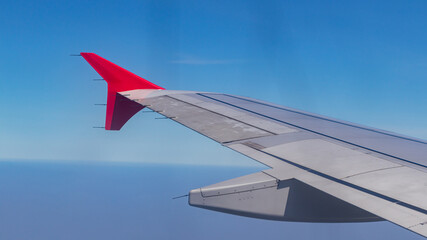 Fototapeta premium Wing of an airplane flying above clouds. Wing of an airplane. view from the window of an airplane flying.