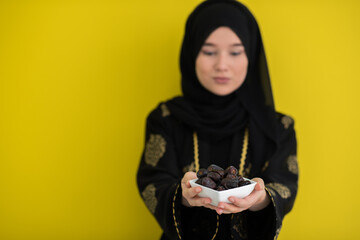 modern muslim woman holding a plate full of sweet dates on iftar time in ramadan kareem islamic...