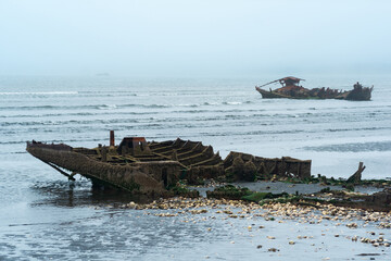 remains of a wrecked ships on a foggy seashore