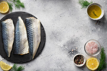fresh fillet mackerel fish on slate board with aromatic herbs, spices, lemon and olive oil. seafood background. copy space - obrazy, fototapety, plakaty