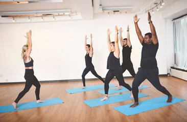 Fototapeta na wymiar group of people with personal trainer doing yoga exercises on mats in gym
