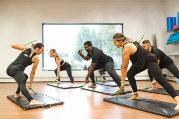 Fitness Teachers with Green Drum Stick at the gym with a training group of peole