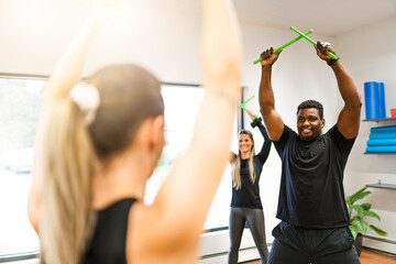 Fitness Teachers with Green Drum Stick at the gym with a training group of peole