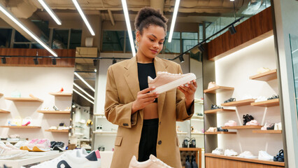 Shopping in the store. A young woman chooses new shoes