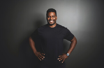 Fototapeta premium Portrait of a man trainer at fitness gym black background. Workout training in fitness gym.