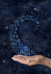 Numerologist working with numbers - male hand with a spiral of random numbers rising from palm...