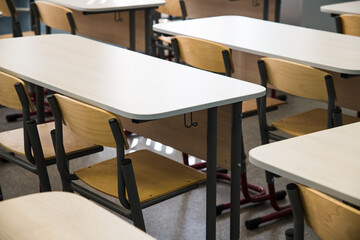 School desks in a row facing the blackboard in an empty classroom