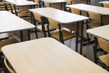 School desks in a row facing the blackboard in an empty classroom