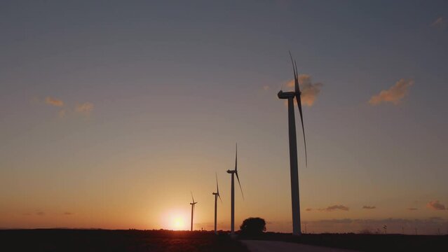 A timelapse at sunset with wind turbines.