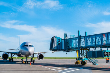 Jet bridge at the airport is brought to a large passenger plane