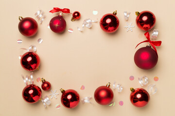 Christmas ball toys and confetti on color background, top view