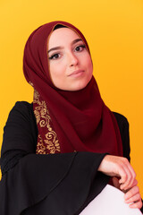 beautiful muslim woman in fashinable dress with hijab isolated on modern yellow background representing concept of modern islam and ramadan kareem