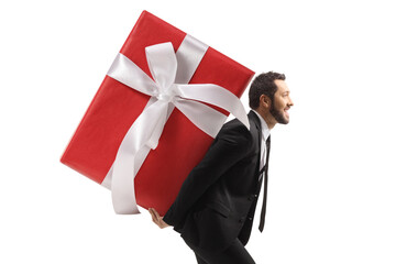 Profile shot of a businessman carrying a big wrapped present on his back