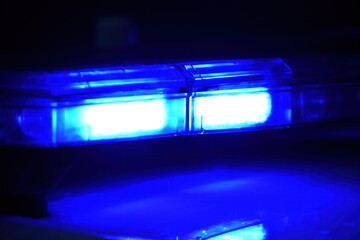 Police car with blue light on the street at night, selective focus