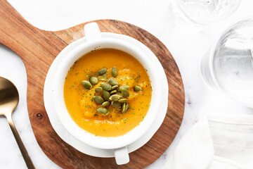 Homemade pumpkin cream in a white bowl. Vegetarian and vegan food ready to eat. Delicious vegetable cream