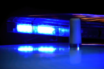 Police car with blue light on the street at night, selective focus