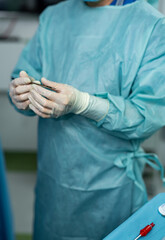 Surgery professional sterile uniform. Operating specialist in uniform working with instruments.