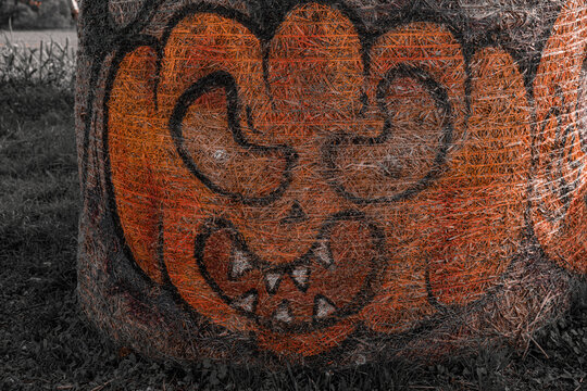 a halloween pumpkin picture on a hay roll