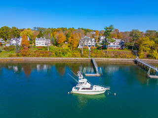 Yacht on York River and historic waterfront building aerial view in fall in village of York Harbor, town of York, Maine ME, USA. 