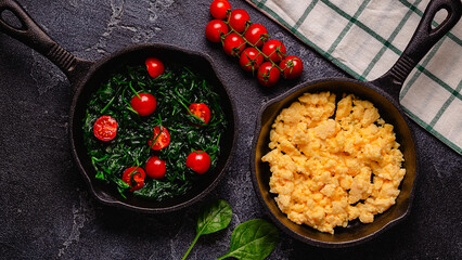 Cooked omelet and spinach with tomatoes in pans