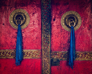 Vintage retro effect filtered hipster style image of gate of Spituk Gompa (Tibetan Buddhist monastery) with ornamented decorated door handles. Ladakh, India